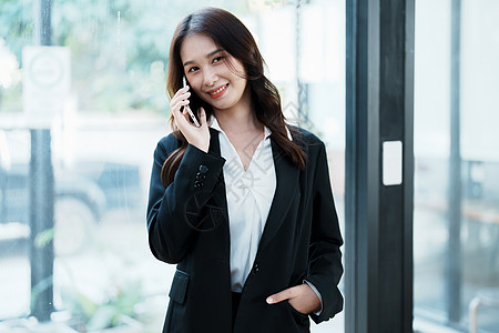 企业业主或亚洲女性营销商在办公室工作时使用商业电话以及文档电脑水平人士商务女士成人手机讨论文书图片