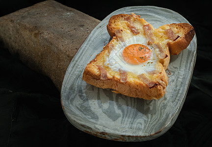 黑底陶瓷盘上的烤培根和奶酪烤面包里自制的炸鸡蛋作品深色甜点糕点小吃背景黄油午餐木头蛋黄图片