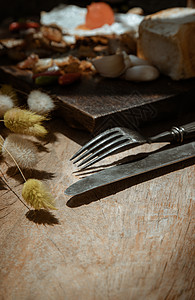 旧的金属刀和叉子和干枯的兔子尾草花 放在旧的铁制木制餐桌上餐具设计木材干花钢刀纹理灯光艺术银叉静物图片