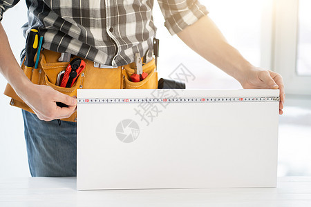 工人用磁带测量家具板图片