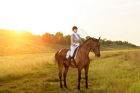 马术运动 年轻女子骑马参加着装高级试练竞赛步幅女性骑士场地阳光动物晴天时尚展示图片