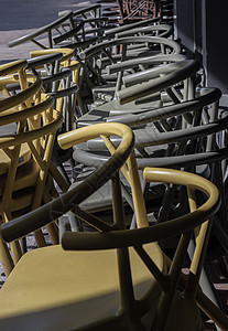 深绿色Khaki颜色和黄色塑料椅的堆叠细节家具座位太阳光线阴影椅子咖啡店桌子装饰风格餐厅图片