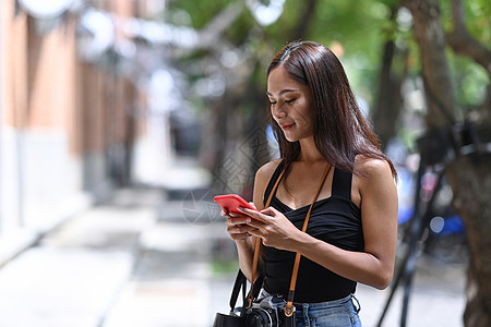 年轻快乐的女人站在街上 用智能手机打着电话图片