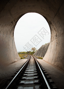 在铁路隧道和铁路内部 尽头有自然光 隧道尽头的光 光与影 实现目标的概念圆弧黑色石头轨道洞穴岩石入口风景黑暗希望图片
