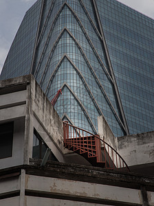 以红铁螺旋阶梯覆盖现代高楼建筑外部和旧屋大楼的建筑图景 这引起了人们的兴趣 笑声纹理市中心天空背景商业场景反射风景城市摩天大楼图片