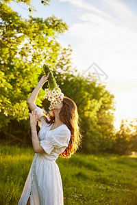 日落时一束花朵的香味中 一位红头发女人在大自然中的垂直肖像图片