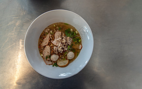泰国辣味面汤 还有白瓷碗中的猪肉和鱼球图片