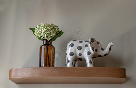 棕色玻璃瓶中的一束绿花和大象在起居室木架上制成陶瓷玻璃工艺作品装饰家居花束家具陶器手工热情图片