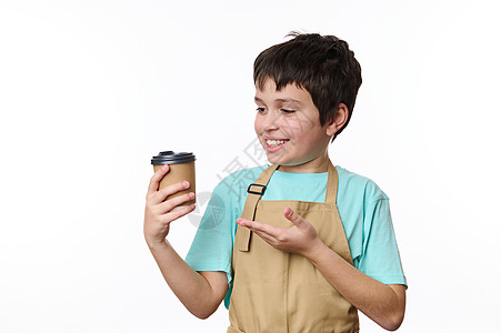 令人惊叹的十几岁男孩 - 小酒吧招待员在厨师围裙上 在纸杯中卖出一个外送热饮图片