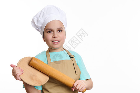 少年男孩     穿主厨制服的面包师美食员 装上照相机 用木板砍板和手握滚动针头图片