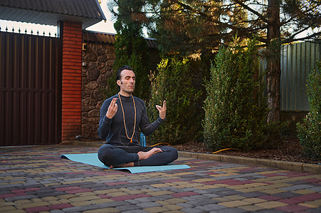 坐着莲花的帅帅运动员 练瑜伽 在日落时做呼吸锻炼 喘口气的时刻图片