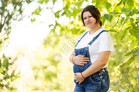 美丽的孕妇 在公园外面放松的美丽女士父母成人母亲幸福怀孕生育力天空艺术树木女性图片