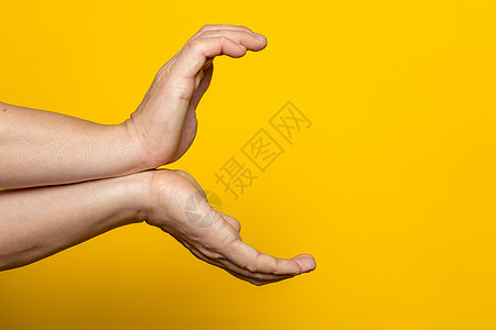 雄性强壮的手举着甘美的姿势 准备发出一股重要的能量 在黄色背景上孤立无援图片