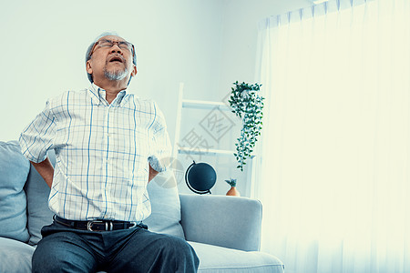 一个痛苦的老人因为背部疼痛而忍住后背保健工人老年志愿者家庭医生看门人病人治疗女士图片