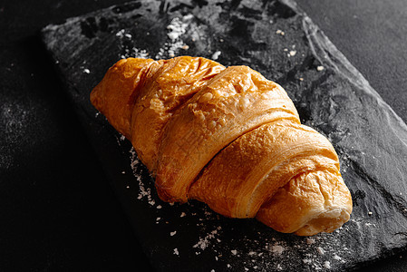 黑色背景的大型羊角面包 新鲜和美味的法国糕点 面包房概念 近视图像图片