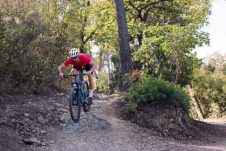 骑自行车的骑自行车者在山上骑脚踏车娱乐头盔成人闲暇风镜山地车小路衬套男性男人图片