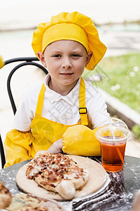 厨师帽和黄色围裙制服 配有卡查普里和夏季柠檬水 很有吸引力的烹饪儿童男孩图片