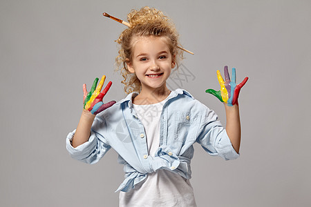美丽的小女孩 手沾满了油漆的手 在灰色背景上摆着姿势艺术压痛工艺绘画金发头发童年水彩教育幸福图片