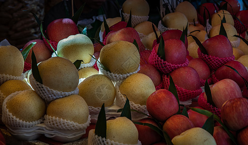 一堆红苹果和黄色的中国梨 供市集出售图片
