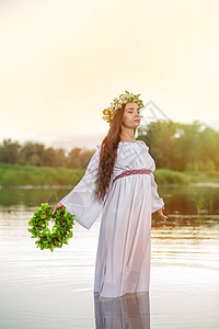 穿着白色连衣裙的女人在水中 头戴花圈的艺术女人在河中 她头上的花环 斯拉夫传统和异教异教徒精神女士女子背景衣服礼服新娘裙子冒充图片