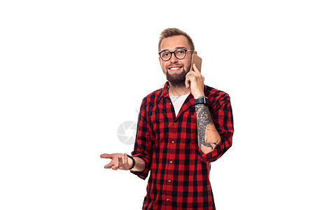 一位在电话上讲话 笑着微笑的无名青年男子的肖像 当时他正往远处看 某个地方手机衬衫格子技术白色红色成人男人幸福细胞图片