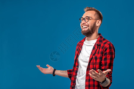 情感和人的概念 年轻留胡子的穿着格斗衬衫的男人 嬉皮士风格成人情绪潮人工作室展示男性手势蓝色胡须快乐图片