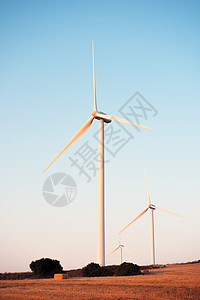 风力农场三辆风车的垂直照片图片