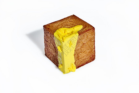 新鲜出炉的整个烤立方羊角面包 上面覆盖着黄色糖霜和巧克力片 背景为白色 创意品种的传统甜糕点图片