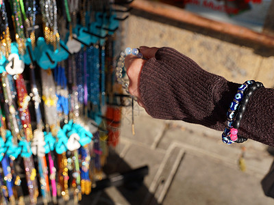 女人的手在阳光下的街头集市上选择手镯销售珠宝纪念品项链贸易配饰店铺购物街道奢华图片