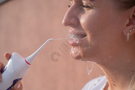 牙齿上有牙套的女人用的是喷水器 近身肖像女孩打扫牙科保健医生女性微笑嘴唇牙线牙刷图片