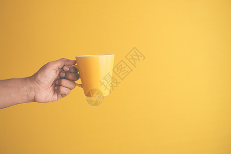 手举着黄色杯子的人创造力男人黑色咖啡享受图片
