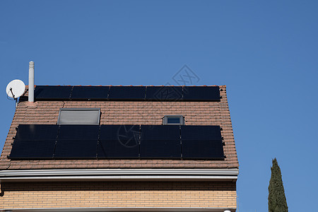 黑色光电板 在小屋屋顶上 面对清蓝的天空背景图片