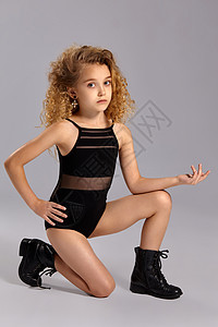 穿着黑色运动泳衣和灰色背面靴子的漂亮女孩体操运动员婴儿配饰鞋带孩子工作室女性青少年膝盖后代小学生图片