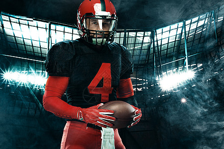 美国足球运动员的特写肖像 在大舞台背景上戴着红色头盔的运动员运动员 体育和动机壁纸男性赛跑者联盟大学运动黑暗体育场团队竞赛挑战图片