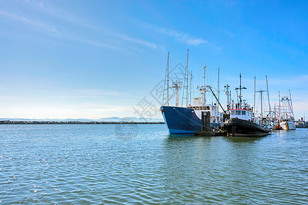 在海洋码头停泊的小型拖网渔船和拖船图片