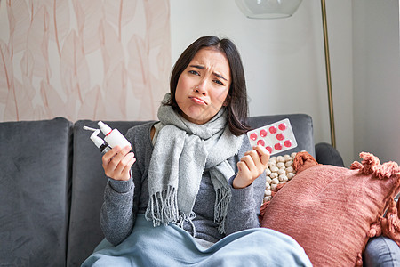 韩国妇女展示药丸 喉咙喷雾酸痛 生病 在家感觉不舒服 冬天感寒冷等情况成人症状女性温度计感染鼻子组织沙发长椅女士图片
