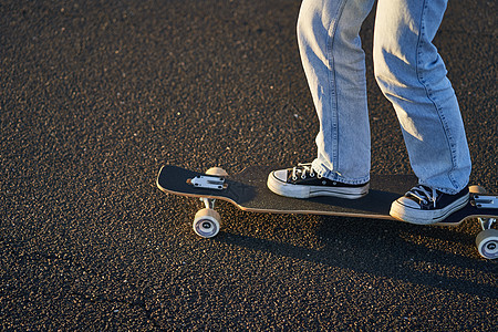 长板上的腿被割伤 Skater女孩在街上滑板上骑着滑板公园潮人滑冰街道太阳木板女士运动青年行动图片