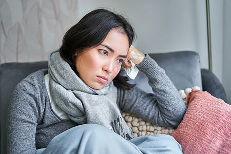 悲伤的女人身体不适 在家里穿着暖和的衣服和围巾 没有暖气 在家里请病假互联网组织房子疾病成人症状温度计长椅病人女性图片