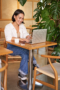 拥有笔记本电脑 坐在咖啡馆 从事计算机工作 管理商业和喝咖啡的时尚女商务人士黑发上网咖啡店女性经理人士酒吧眼镜学生商务图片