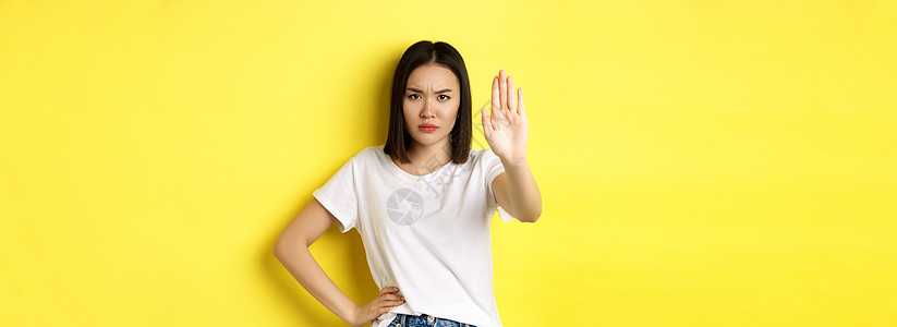 自信而严肃的亚洲女人说不 表现出停止的手势来禁止和警告 与某人持不同意见 对黄色背景感到不满快乐情感发型学生商业黑发女孩理发交易图片