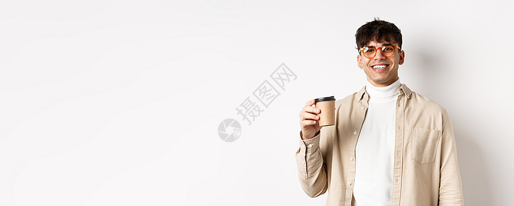 真实的人 快乐的年轻人用纸杯喝咖啡 在最喜欢的咖啡馆点外卖 微笑着看着相机 白色背景发型生活商业促销黑发杯子咖啡饮料广告成人图片