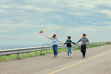 渐进式家庭快乐度假概念 在路边放户外飞行风筝父母街道跑步喜悦闲暇儿子阳光母亲乐趣幸福图片