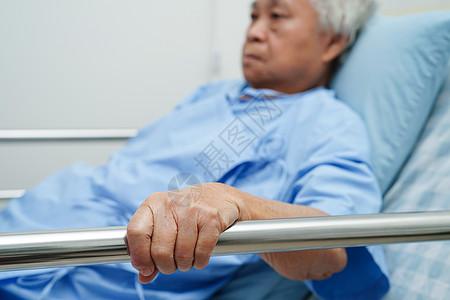 亚洲年长的老年女性患者在床边站着 却躺在床上等待家人住院 但希望她能安然无恙护士照顾者医生病人药品家庭男人帮助皱纹母亲图片