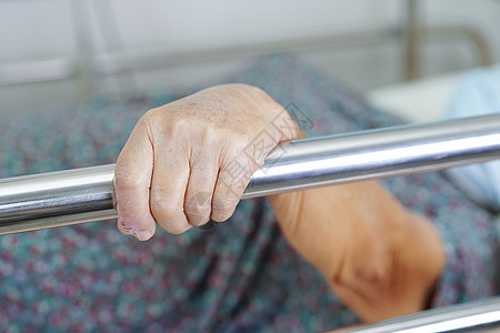 亚洲年长的老年女性患者在床边站着 却躺在床上等待家人住院 但希望她能安然无恙医生男人药品手指中风生活疾病母亲护士照顾者图片
