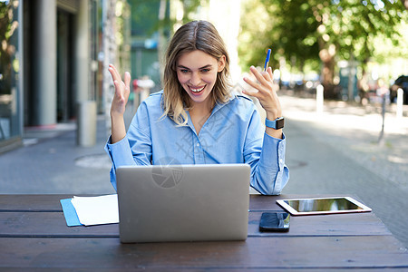 年轻的女商务人士 参加在线视频会议 写下 工作 在她的文件中做笔记 坐在外面呼吸新鲜空气商务人士公司职场笔记本营销女士代理人电话图片