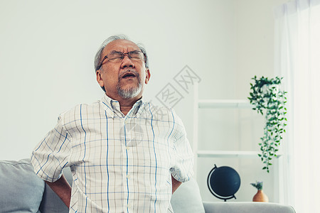 一个痛苦的老人因为背部疼痛而忍住后背护理女性房间工人医生家庭帮助志愿者医院保健图片