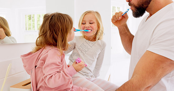 家庭中的父亲 孩子和刷牙牙科保健 清洁和浴室卫生 快乐的爸爸用牙膏 牙刷和健康的生活方式教小女孩口腔健康图片