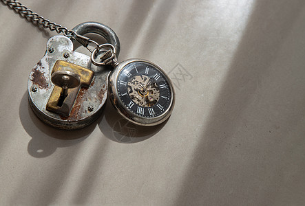 旧式手表和老旧的铁锁 在白色背景上穿透了光线挂锁钥匙小时艺术阳光时间金属放松生活倒数图片