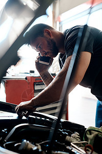 我发现了问题 一个机械工在汽车修理店工作时 正在用手机说话 - 是的 先生图片