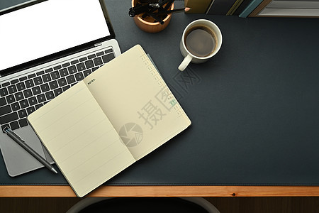 现代工作场所 配备膝上型计算机 空白笔记纸 咖啡杯和黑色皮革背景文具图片